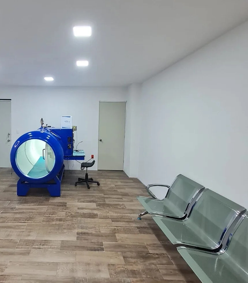 Vista general de la sala: cámara al fondo y bancas de espera a un costado.