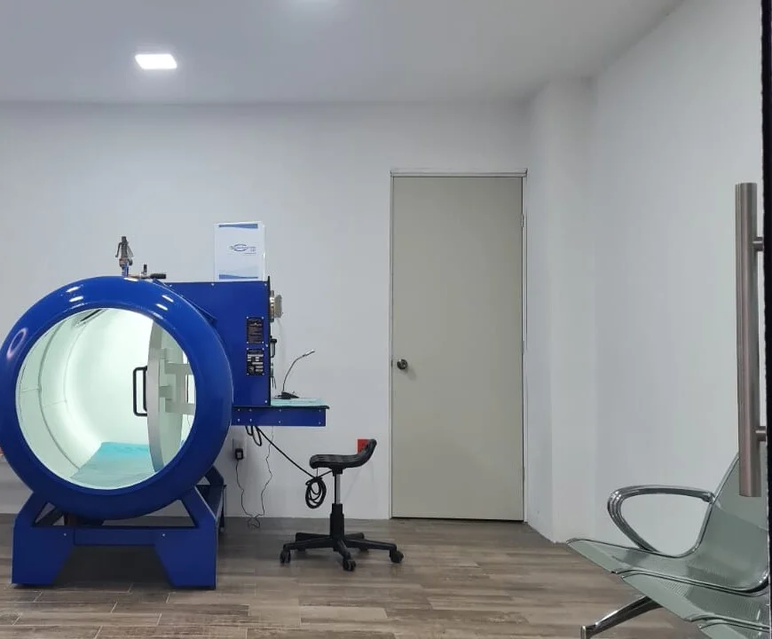Sala de tratamiento con la cámara hiperbárica, su panel de control y el área de espera.